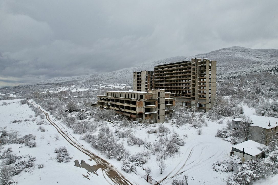The concrete shell of an unfinished hotel in fresh snow