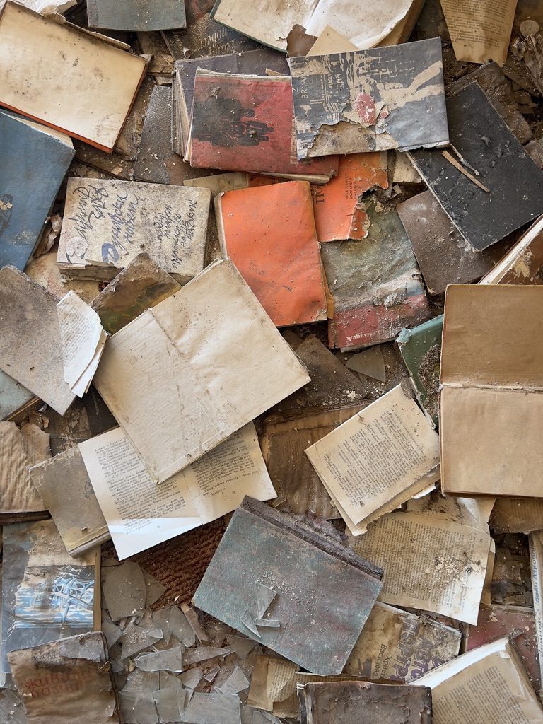 Old books scattered across a dusty floor